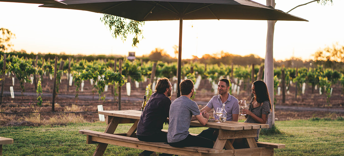 Friends at the Mino + Co cellar door outside near the vines